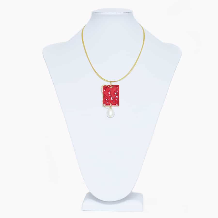 Design pendant made of hand carved coral in silver gilt.